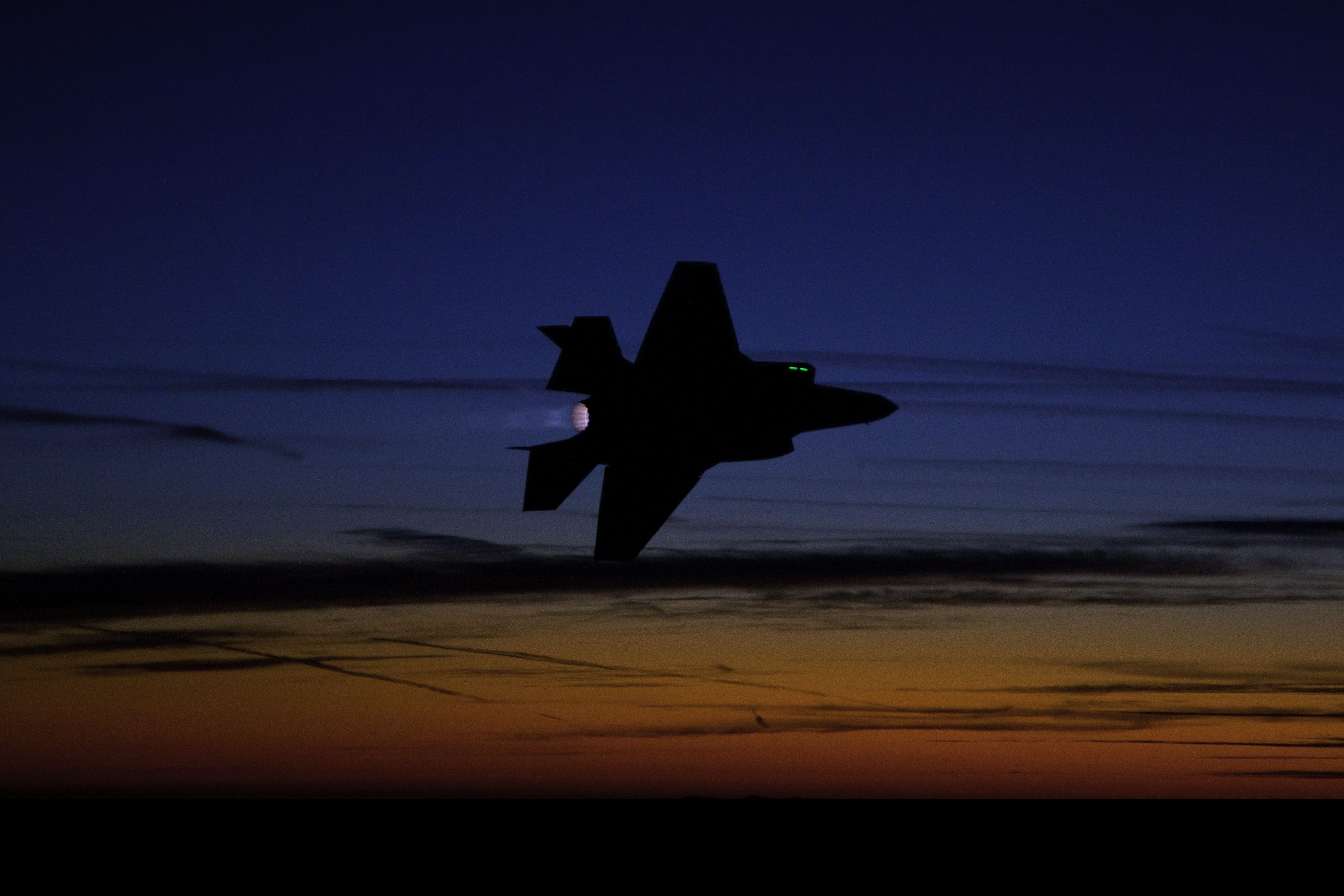 F-35 Fighter Jet flying in the sunset.