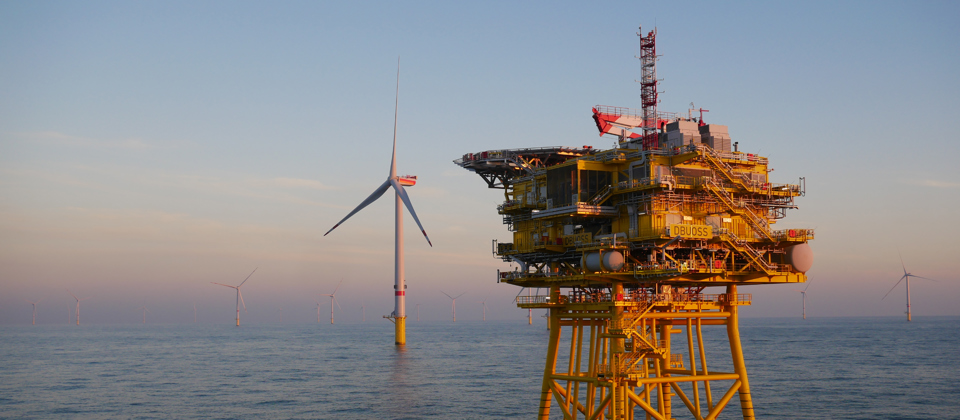 Offshore platform with a wind turbine in the background.