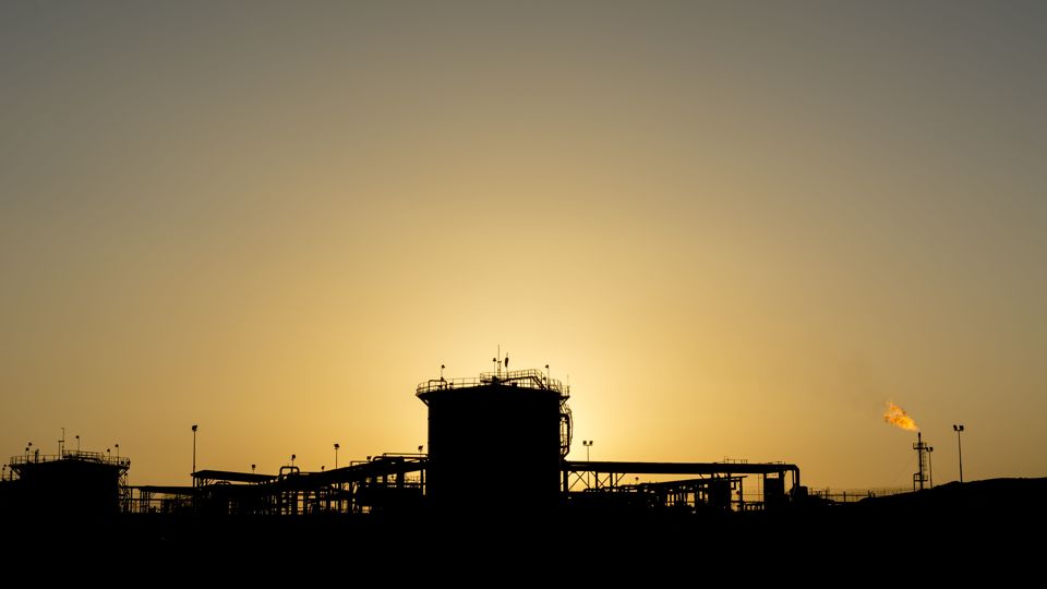 Silhouette of a manifold refinery plant in the oilfield at sunset