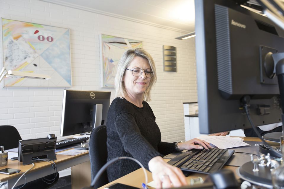 Terma employee working at a desk and smiling.