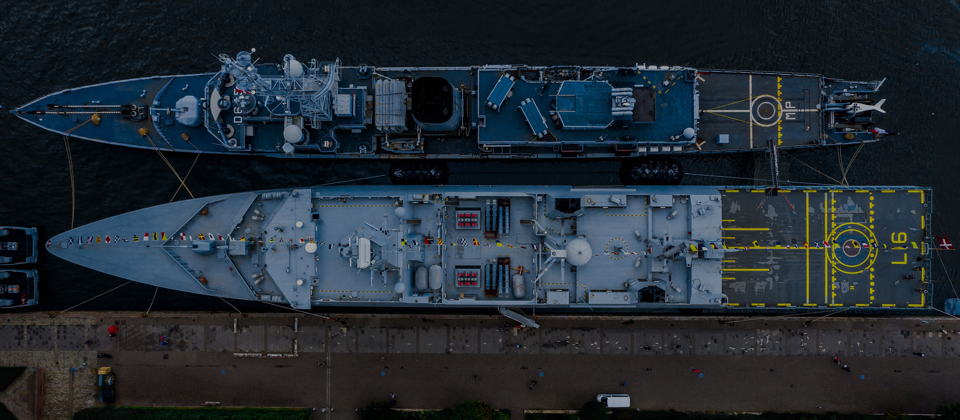 Two docked navy vessels seen form above.