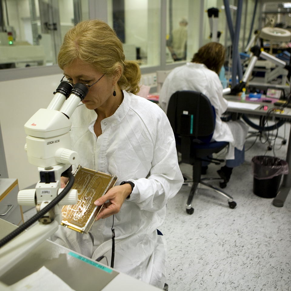 Terma employee looking at a printed circuit board.