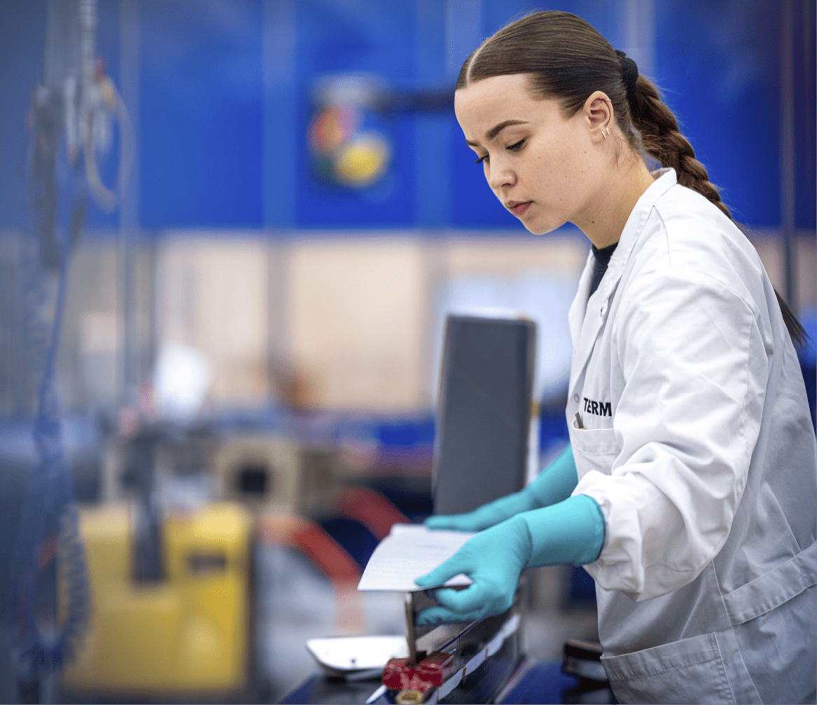 A woman wearing a white lab coat is working in a factory. AI generated content