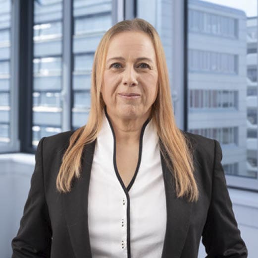 A woman in a black suit stands in front of a window. AI generated content