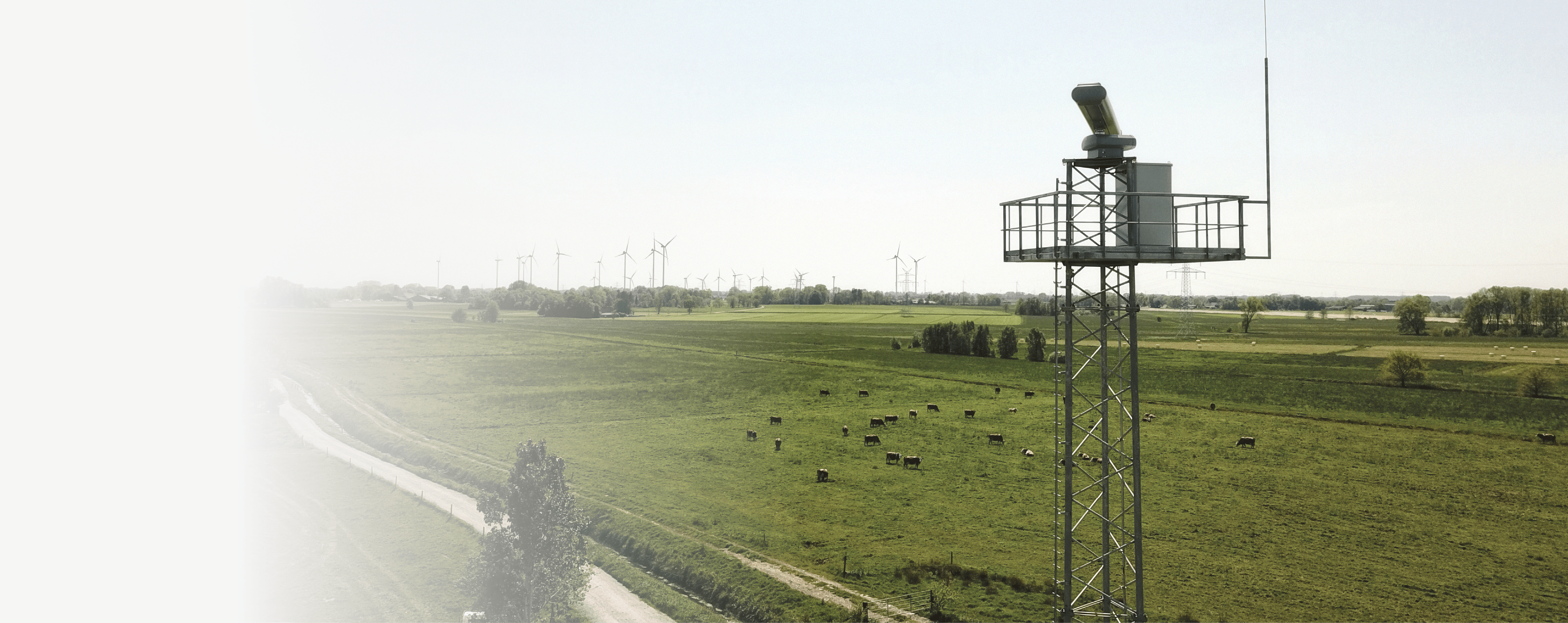 A wind turbine is on a pole in a field. Description generated by AI